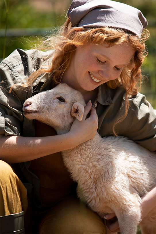 Kobieta z owieczką ciesząca się poznaniem możliwości Reiki